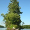 A canoe rests on the shore of a narrow island